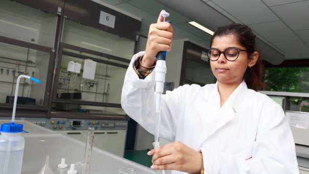 Student pipetteert in het lab.