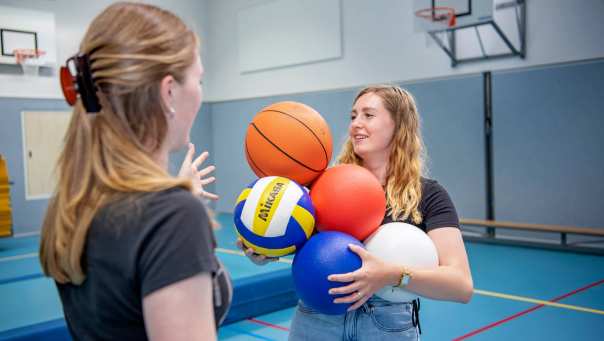 2 meisjes met ballen in gymlokaal