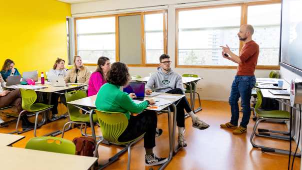 De studenten kijken naar de leraar die hun les geeft in het klaslokaal. 