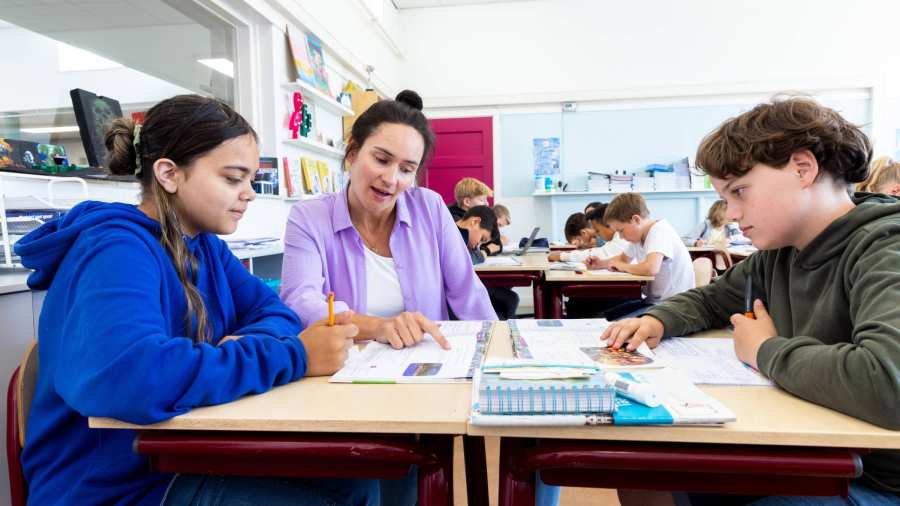 Docent Leonie van de opleiding leraar basisonderwijs aan tafel met leerlingen