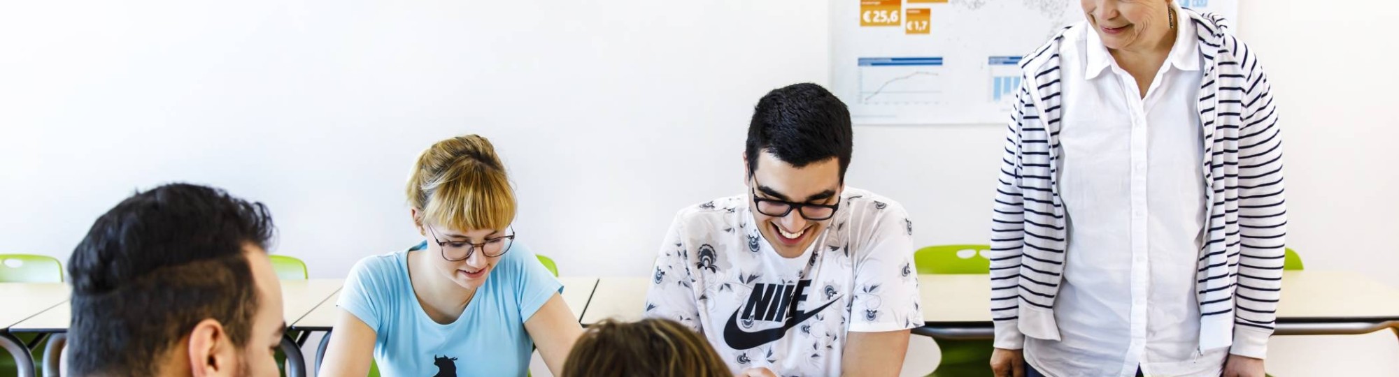 docent kijkt naar leerlingen die aan de slag zijn