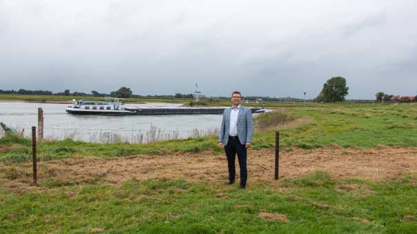 Promovendus Frank den Heijer in rivierenlandschap