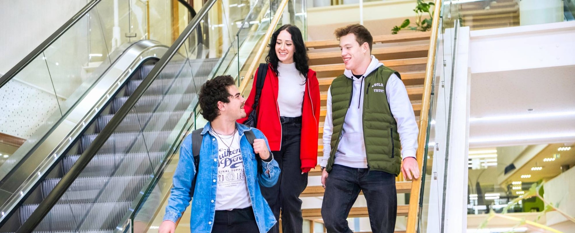 Drie studenten Leraar Natuurkunde lopen samen van de trap af.