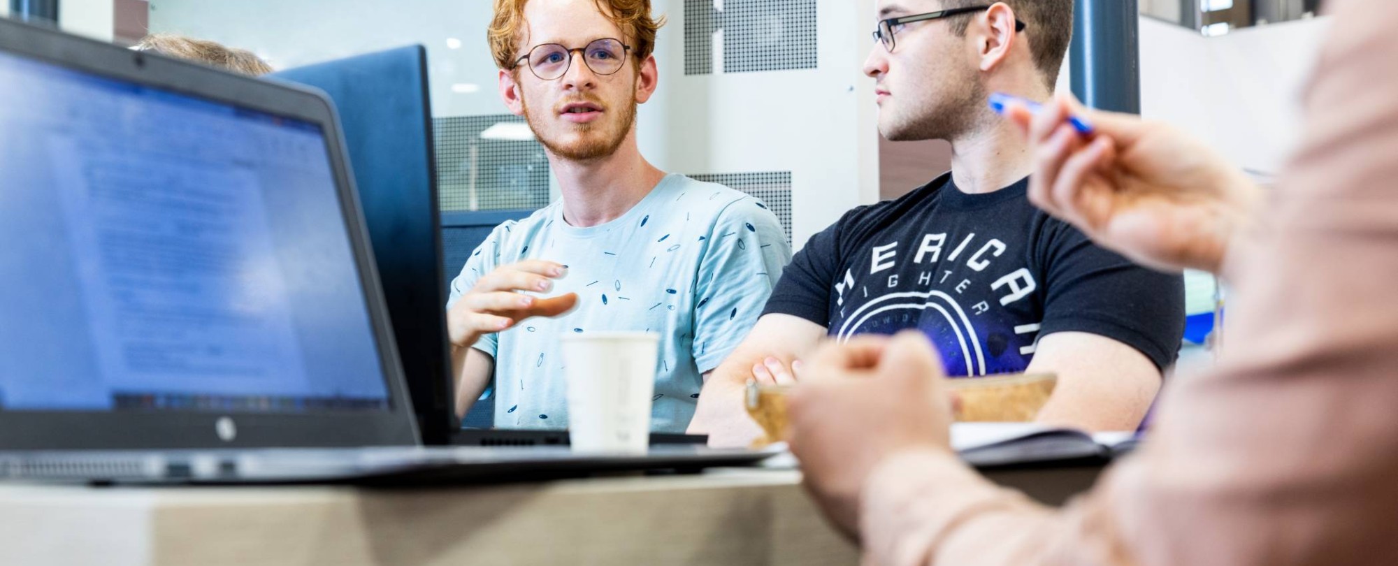 Two Mechanical Engineering students doing group work behind laptops - Werktuigbouwkunde