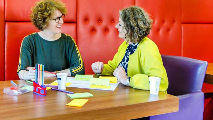 twee docenten vergaderen lachend