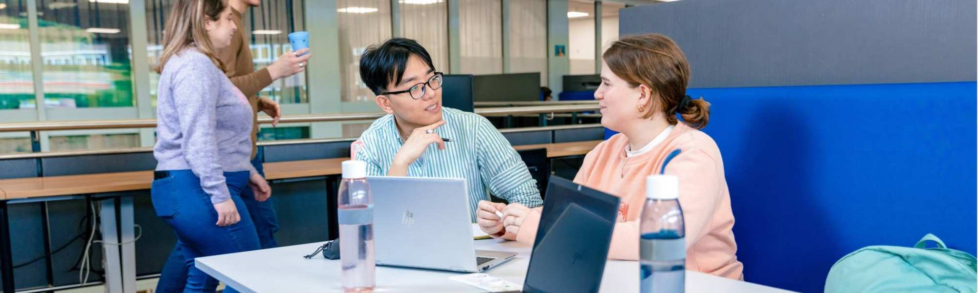 International students Nyugen and Noa studying together in the library on the Arnhem campus of HAN University of Applied Sciences.