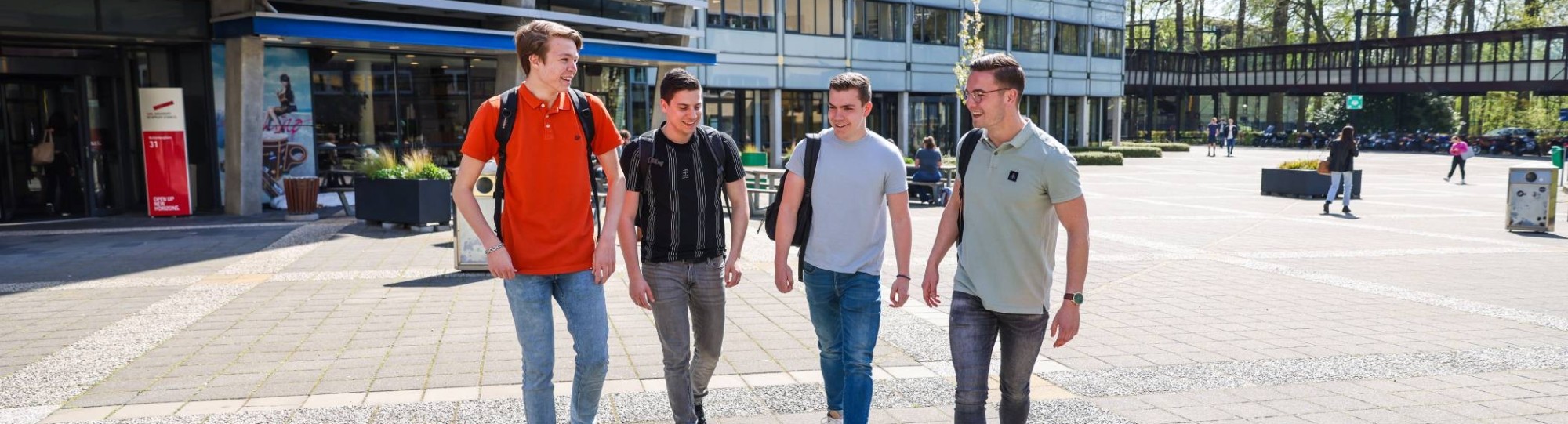 Vier studenten van logistics management lopen buiten bij de campus