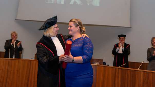 Marieke Rothuizen in een blauwe jurk  samen met haar promotor tijdens haar promotie