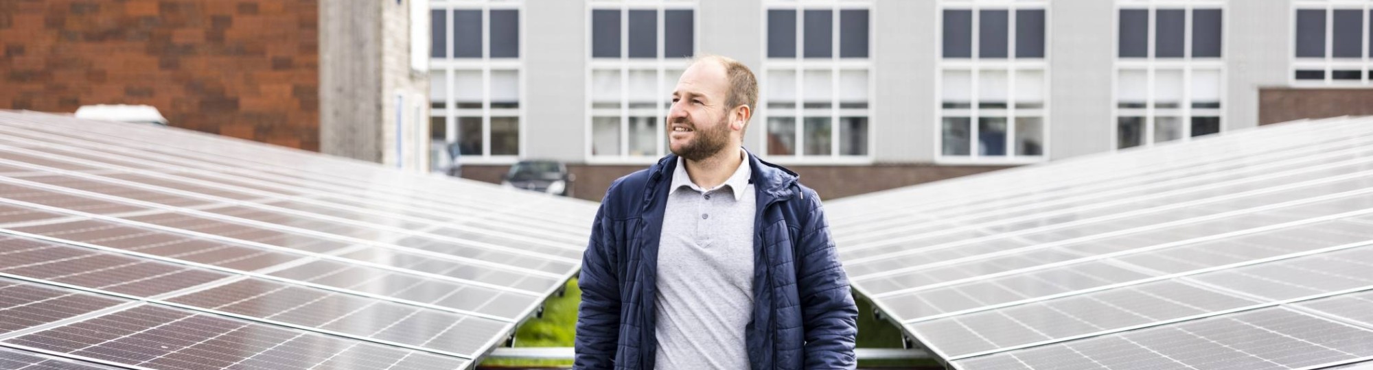 man lopend tussen energiepanelen