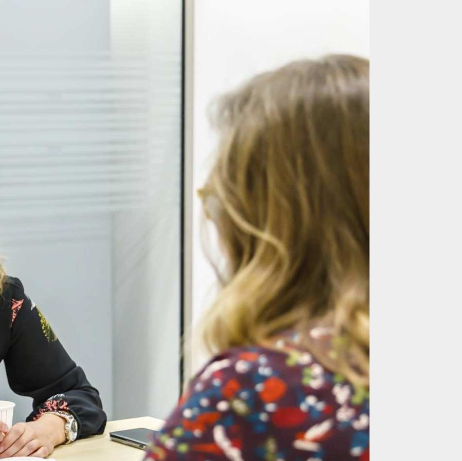 Twee vrouwen aan tafel in gesprek met elkaar