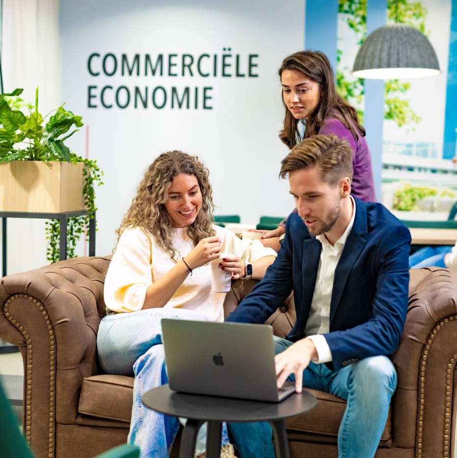 Groepje duaal studenten van de associate degree Commerciële Economie werken op laptop samen op laptop op de HAN campus Arnhem.