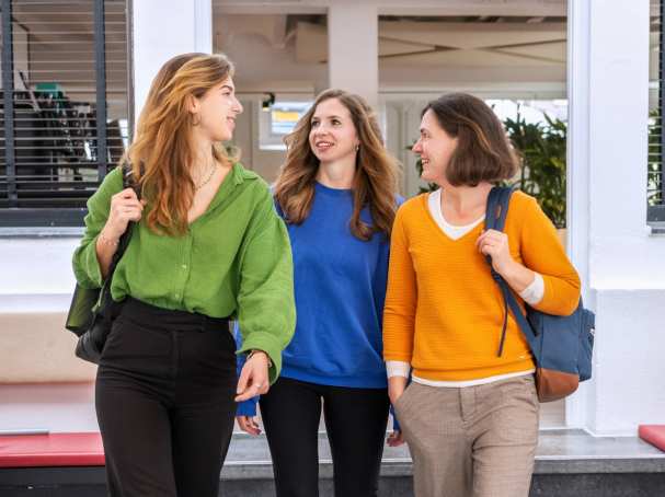 Studenten vooruitlopend op de gang, kijkend naar elkaar. 