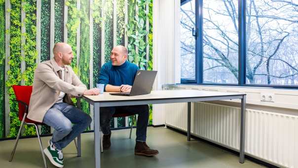 Een studieadviseur en docent heeft een gesprek met een student Bedrijfskunde deeltijd