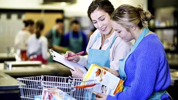 studenten bekijken voedingsproducten uit boodschappenmand