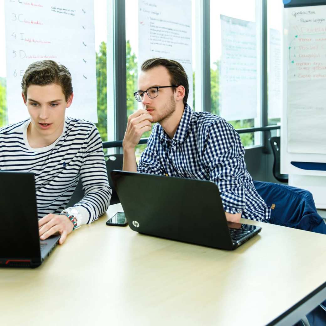 Twee studenten Applied Data Science aan het werk achter de laptop.