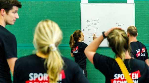 instructie geven op whiteboard in sporthal