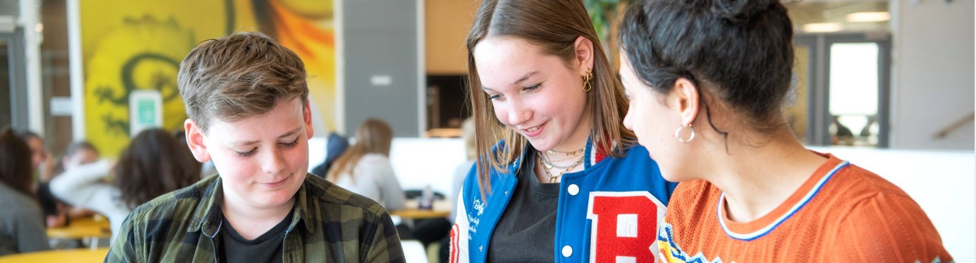 twee studenten in gesprek met docent aan tafel voor de fotoshoot van Leerlab bij Citadel 