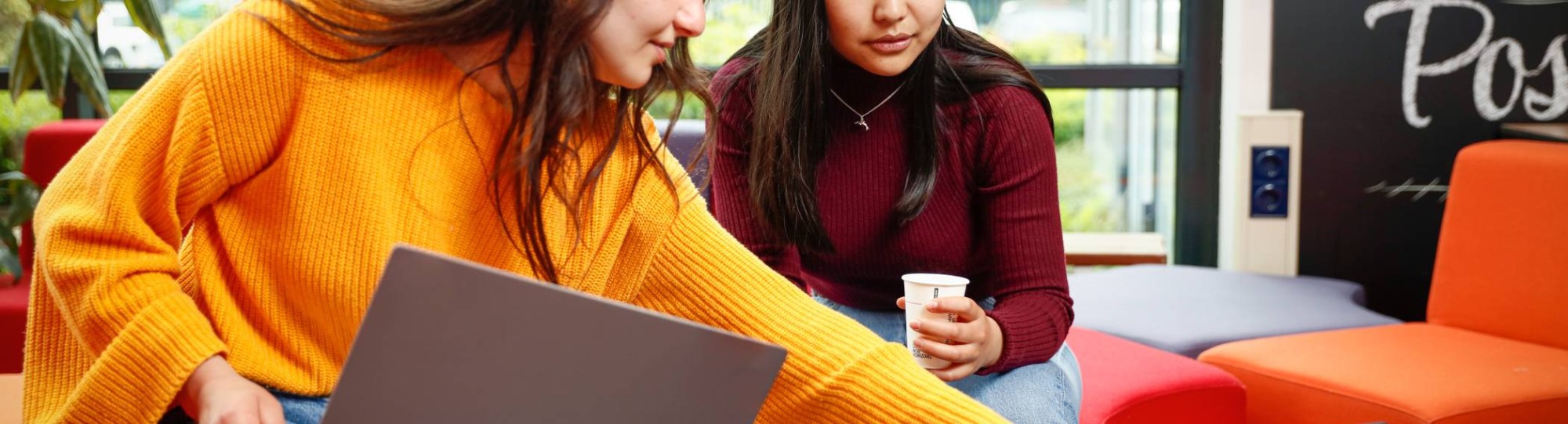 Twee studenten met laptop overleggen en wijst naar scherm