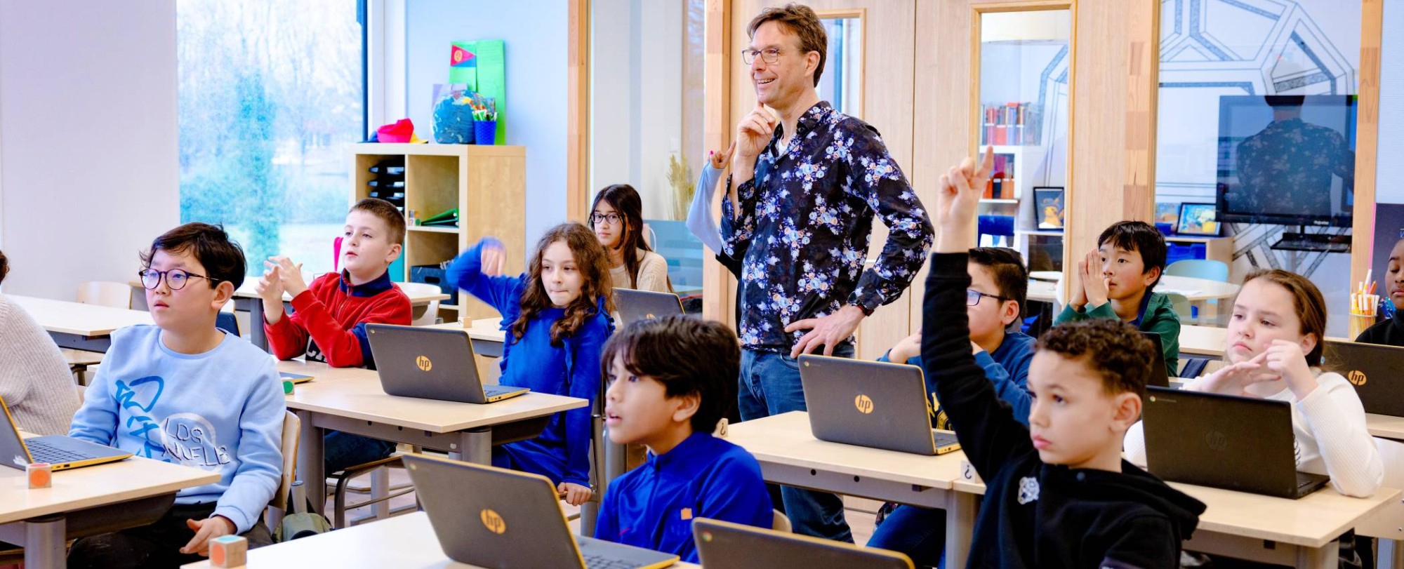 Meester en leerlingen kijken naar het bord