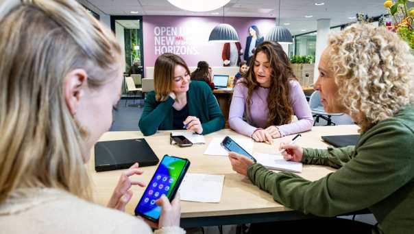 Studenten van Logistiek deeltijd zijn in overleg met hun telefoon