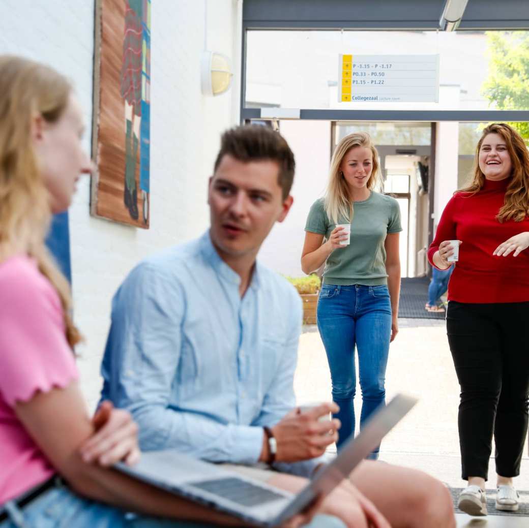 3 masterstudenten lopen samen door de gang op de campus van Nijmegen