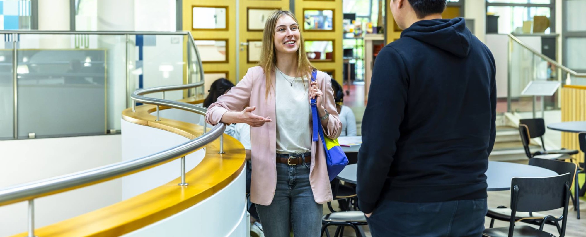 ict student evie in gesprek met klasgenoot op de vide in de b-vleugel