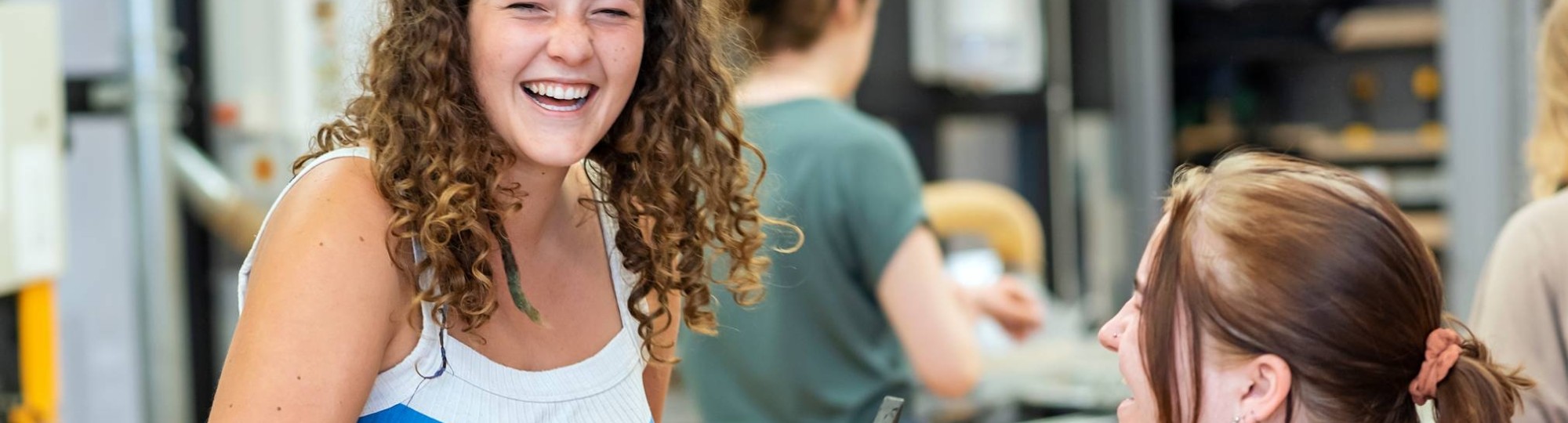 Twee beeldende therapie studenten werken samen aan een project in houtlokaal tijdens een praktijkles