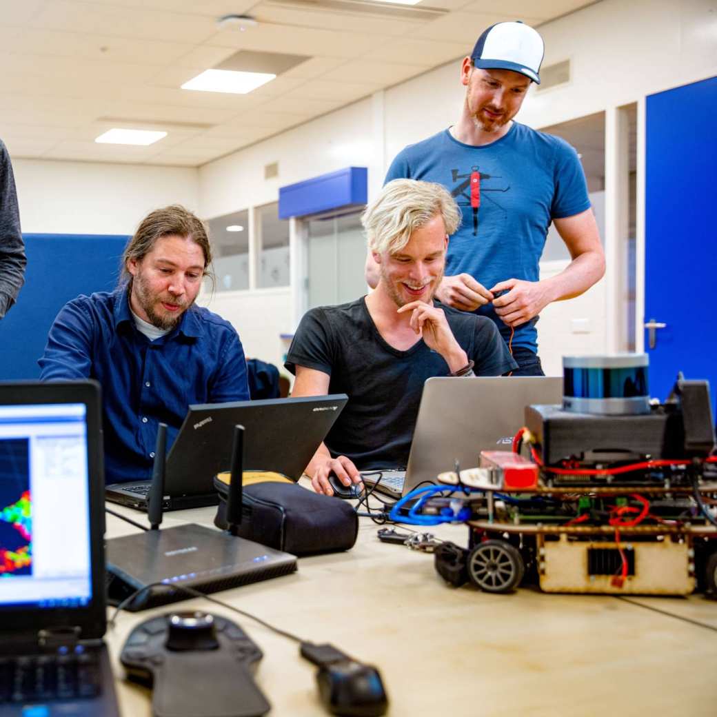 studenten werkt samen aan zelfrijdende auto met laptop