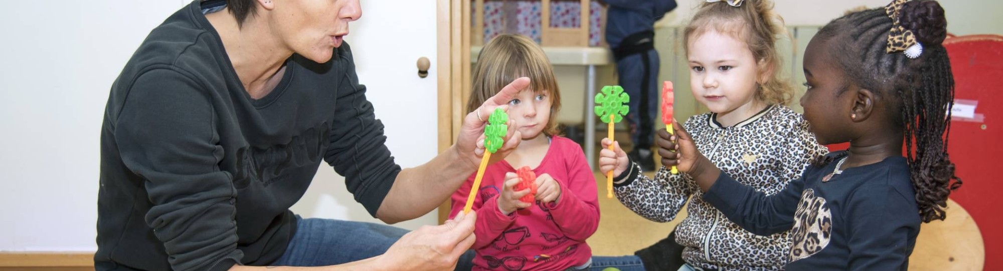 Docent speelt met leerlingen en speelgoed