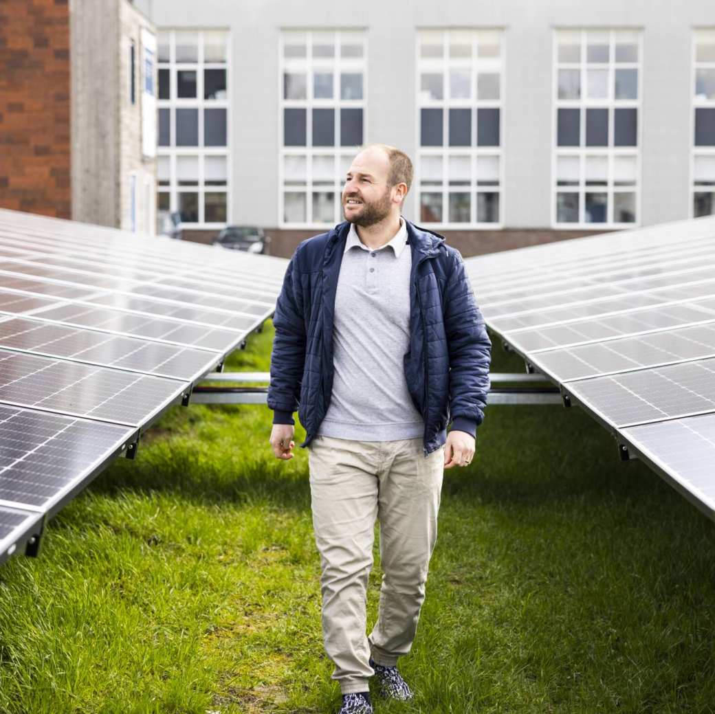 man lopend tussen energiepanelen