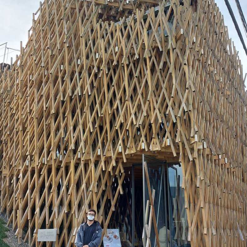 Patrick bij het houtconstructiegebouw van architect Kengo Kuma