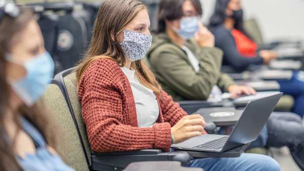 Studenten in collegezaal met mondkapjes op. Covid19. Corona