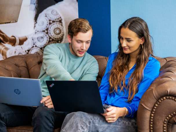 Commerciële Economie 2 studenten op bank met laptop