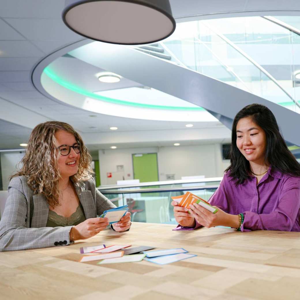 Toegepaste Psychologie TP, foto 2359, studenten doen een kaartspel aan tafel, samenwerken, overleggen