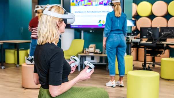 Een vrouwelijke student International Social Work werkt met een VR-bril voor het vak Sociale Technologie.