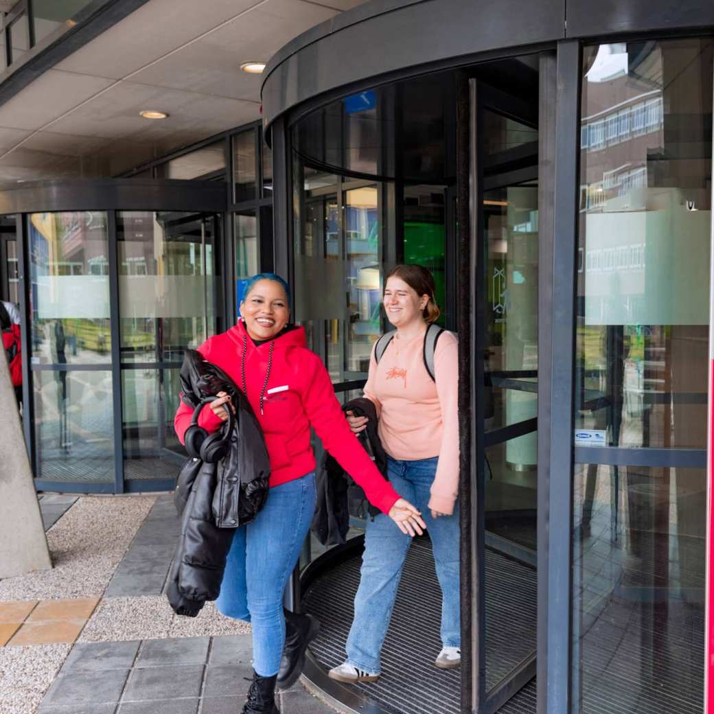 Noa and Chadionne walking through the entrance by Ruitenberglaan 31 HAN Arnhem campus.