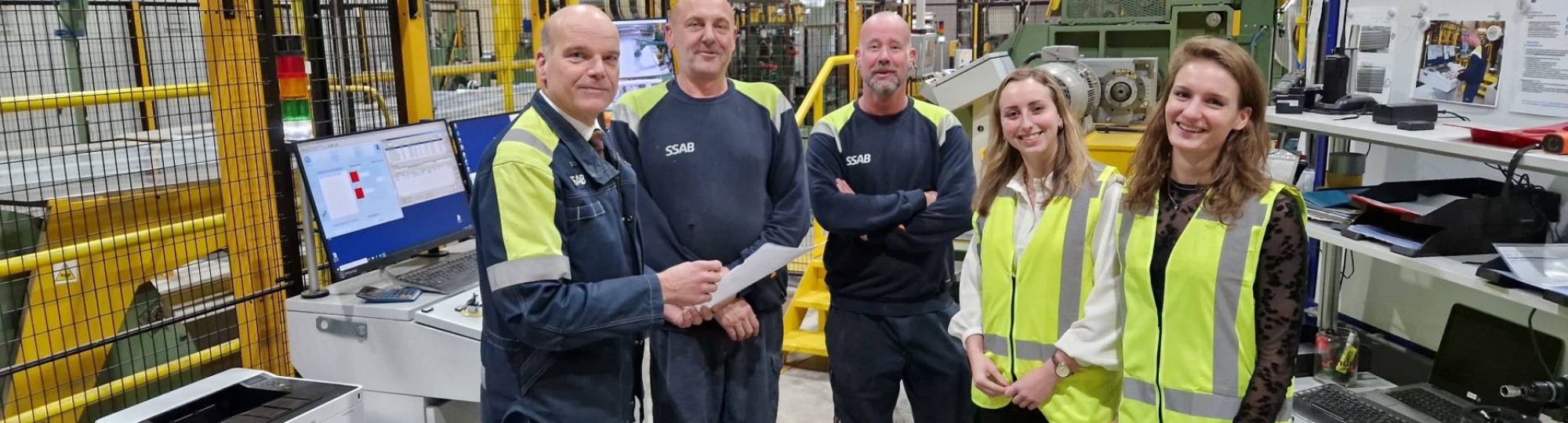 Medewerkers met twee studenten van de Minor Lean Management op de werkvloer bij SSAB