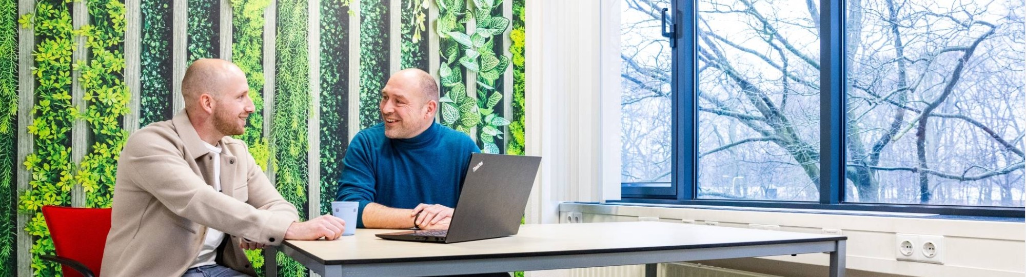 Docent en student Logistiek duaal zitten naast elkaar en kijken naar een laptop