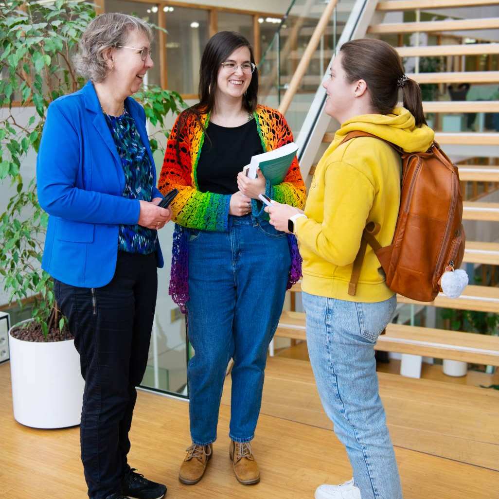 Foto Master Academie Educatie. 3 masterstudenten staan te praten voor de gang op Kapittelweg 35, Nijmegen. 