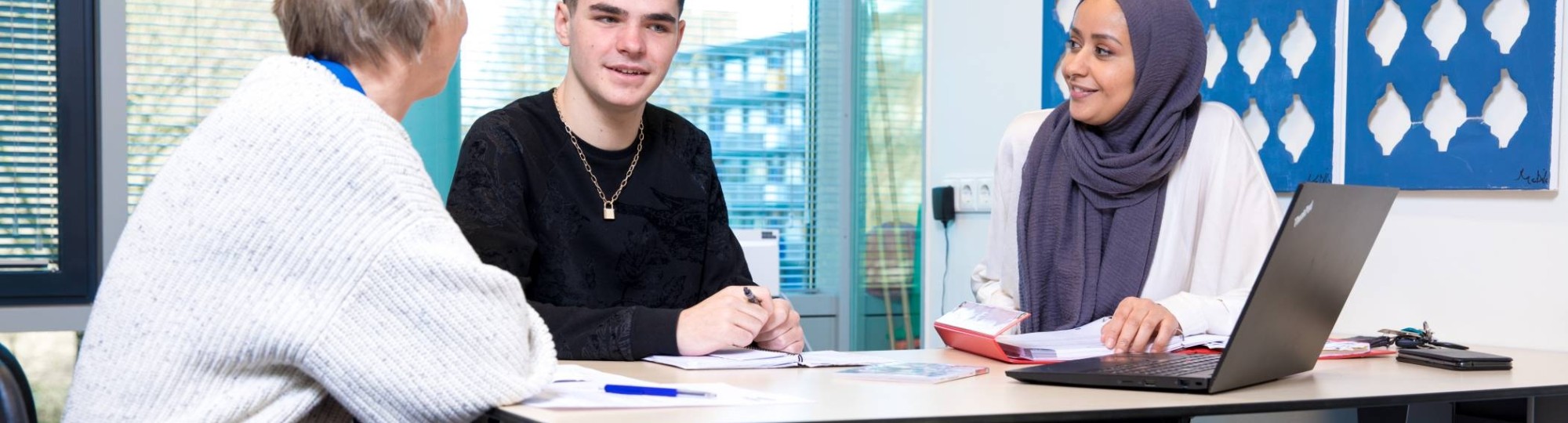 student in gesprek met wijkdocent en professional