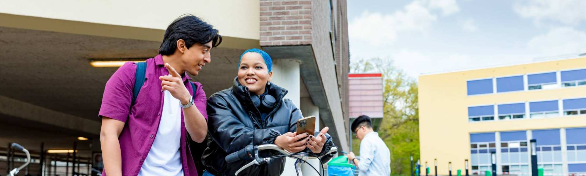 International students Diego and Chadionne with their bikes looking for directions on the Arnhem campus of HAN University of Applied Sciences.