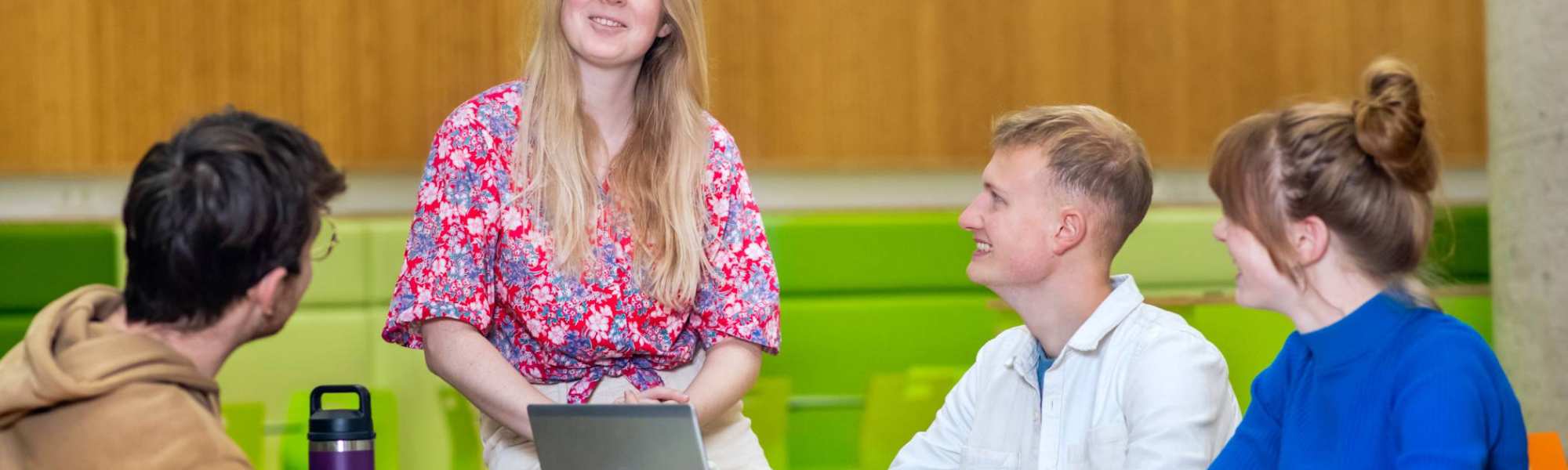 Vier studenten praten samen en lachen allemaal.