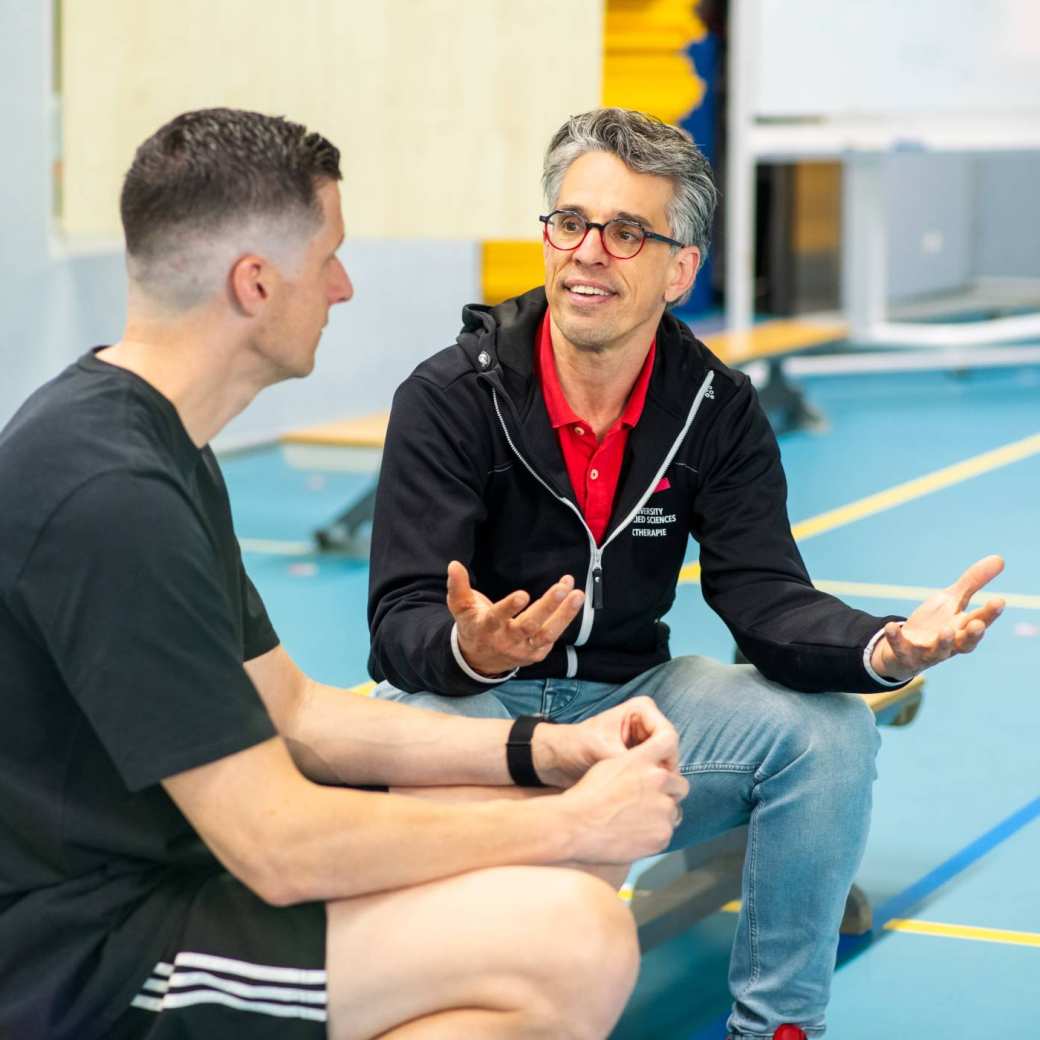 Student en docent in gesprek tijdens les pmt deeltijd