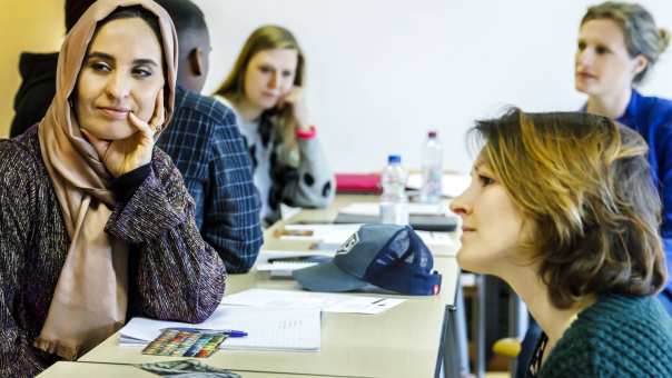 twee vrouwen luisteren naar gesprek