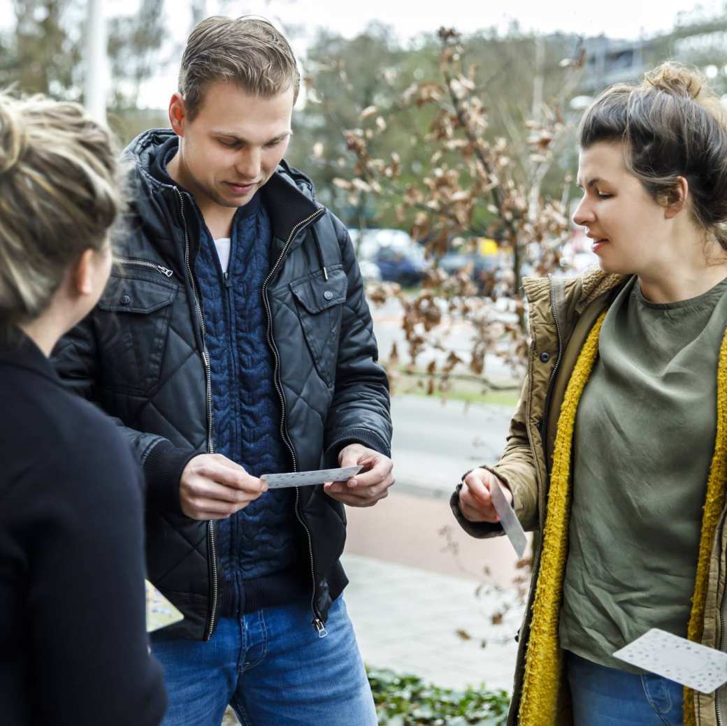 studenten op straat met kaartjes in hand