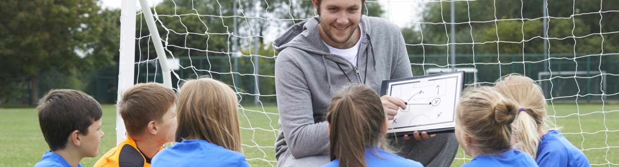 geeft team met basisschool voetbalteam instructie 