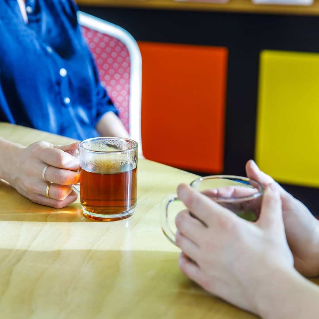 aan tafel thee drinkend in wijkcentrum