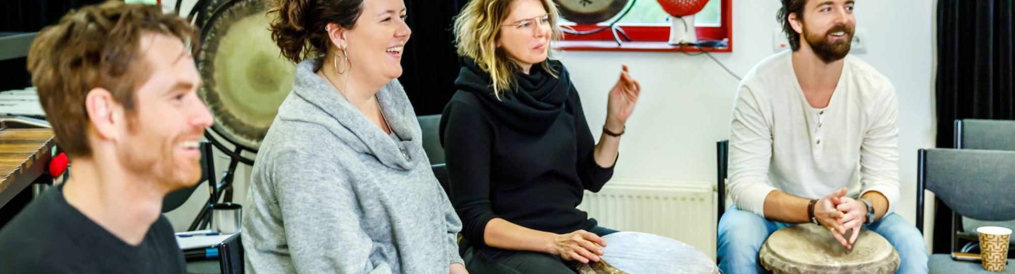 Studenten van de Master Vaktherapie - richting Muziektherapie - slaan op trommels.