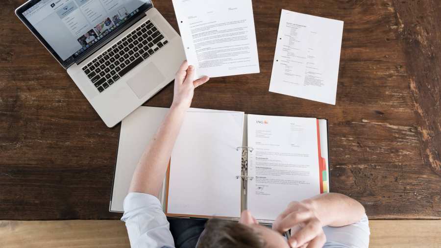 Man leest overheidsbrieven aan tafel 