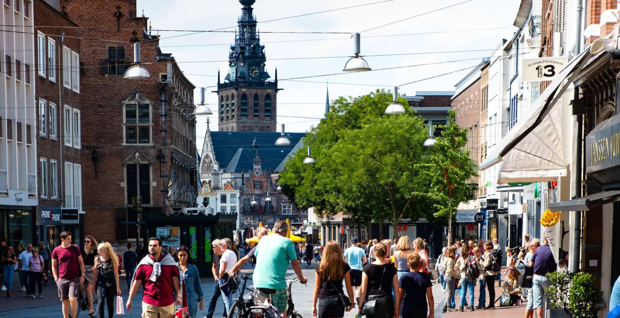 Nijmegen mensen in winkelstraat met kerk op achtergrond